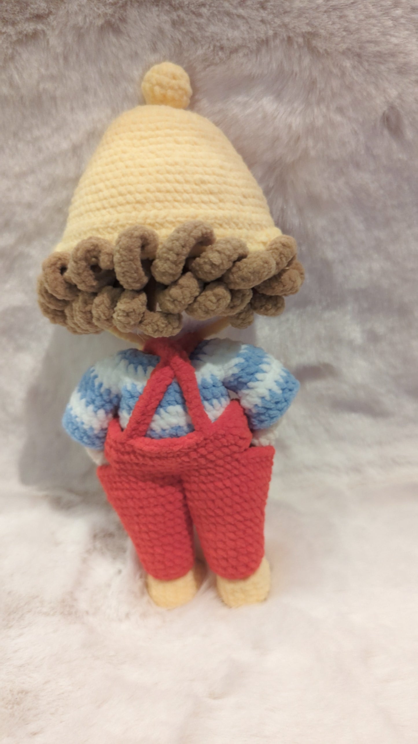 Handmade crochet doll in red overalls